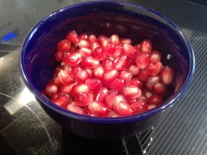 Blue bowl containing red pomegranate seeds