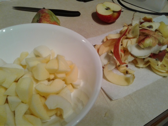 Bowl of apples slices with the apple peels nearby